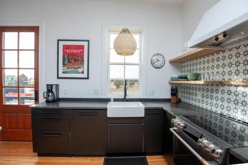 a kitchen with black counters and a sink and a window at South Main Residences by Surf Hotel in Buena Vista