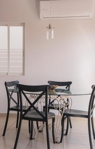 a glass table and chairs in a room with a window at CASA EN PRIVADA FRENTE A LA PLAYA CON ALBERCA! in Mazatlán