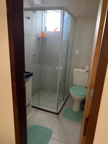 y baño con ducha de cristal y aseo. en Residencial Havaí en João Pessoa