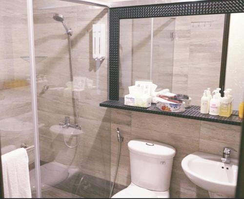 a bathroom with a shower and a toilet and a sink at Yily House怡家居 in Yilan City