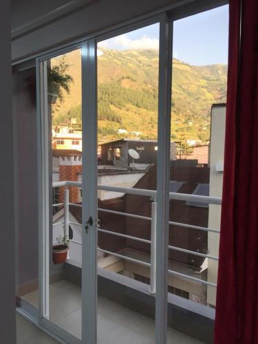 a sliding glass door with a view of a balcony at Casa Gaviota Dorada in Baños