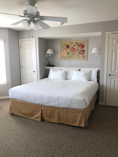 a bedroom with a large white bed with a ceiling fan at Holiday Inn Club Vacation Galveston Seaside Resort in Galveston