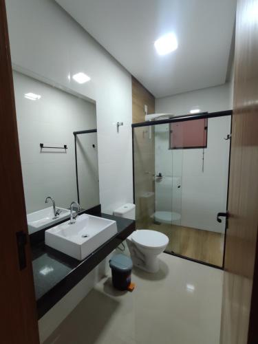 a bathroom with a sink and a toilet at Apartamento One 360° in Capitólio