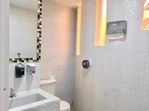 a bathroom with a white toilet and a sink at Casa Gaviota Dorada in Baños