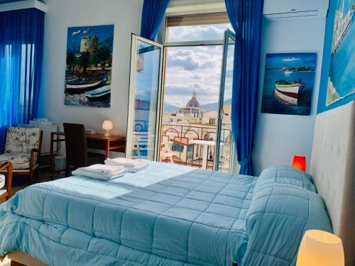 a bedroom with a blue bed and a large window at La Maison del Sole in Palermo