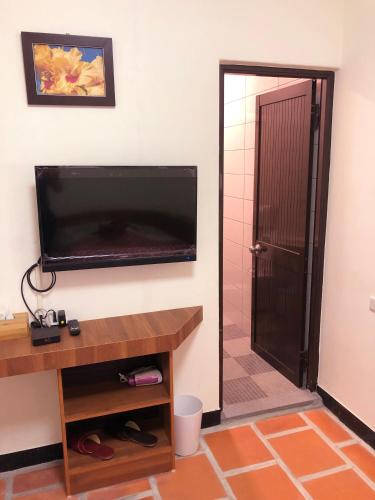 a room with a flat screen tv and a door at 金門后倉七號新古厝民宿 in Jinning