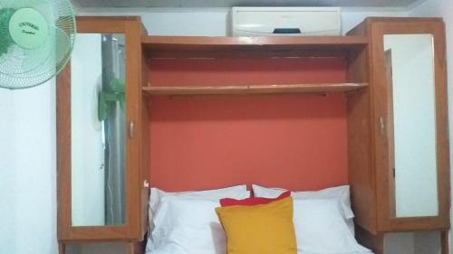 a bunk bed with an orange wall and white pillows at small apartment in Santo Domingo