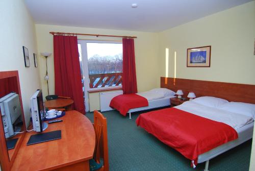 Pokój hotelowy z 2 łóżkami i biurkiem z komputerem w obiekcie Szaman Morski w Jastrzębiej Górze