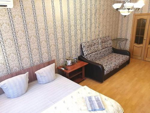 トムスクにあるSovetskaya 50のベッド、ソファ、椅子が備わる客室です。