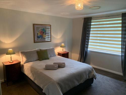 sypialnia z łóżkiem z 2 lampami i oknem w obiekcie Studio Cottages "Bungalow" w mieście Sydney