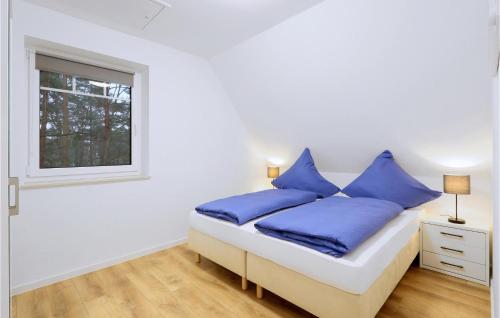 a bedroom with a bed with blue pillows and a window at Reetdachhaus 22 Auf Usedom in Kutzow