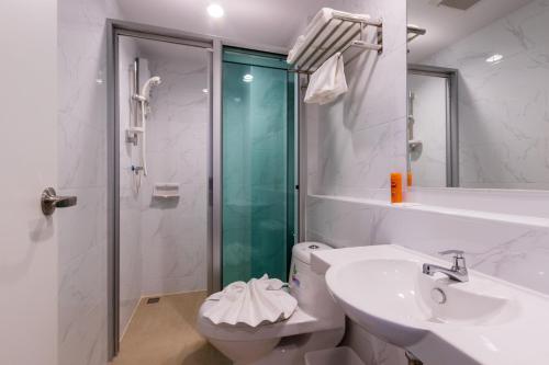 uma casa de banho com um chuveiro, um lavatório e um WC. em The Key Point Hotel em Bangkok