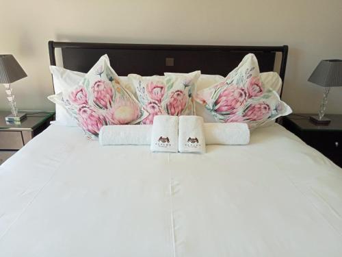 a bed with two towels and pillows on it at Slaley Country House in Stellenbosch