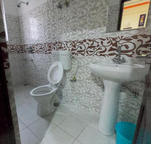 a bathroom with a toilet and a sink at Yes Comfort Villa Guest House in Dharamshala