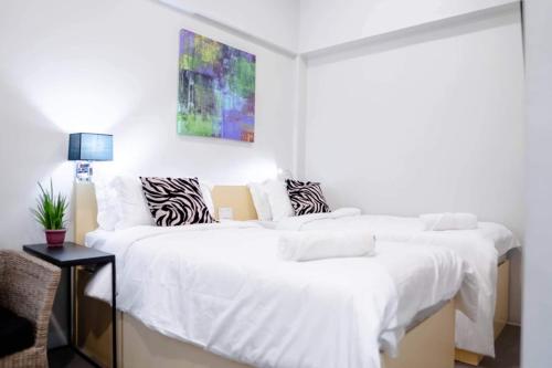 1 dormitorio con 2 camas con sábanas blancas en Radlett Residences Hotel - Tuguegarao en Tuguegarao