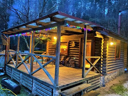 a log cabin with a deck at night at Sodyba Duburiai in Ukmergė