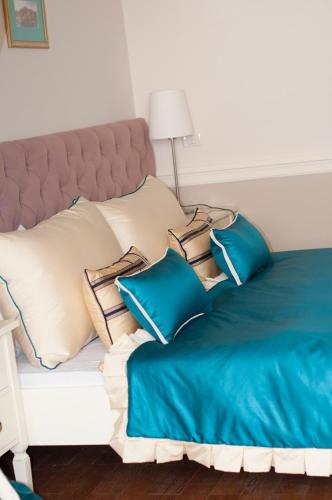 a bed with blue and white pillows on it at Boutique Vila Paradis in Deva