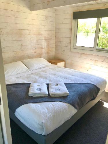 a bedroom with a bed with two towels on it at Jenolan Holiday Park Oberon in Oberon