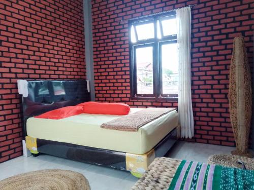 a room with two beds and a window at Kurnia Homestay in Ternate