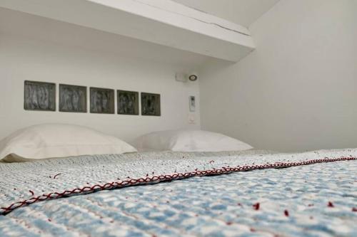 a bedroom with a bed with a red and white comforter at LE ZOLA Appartement solaire in La Ciotat