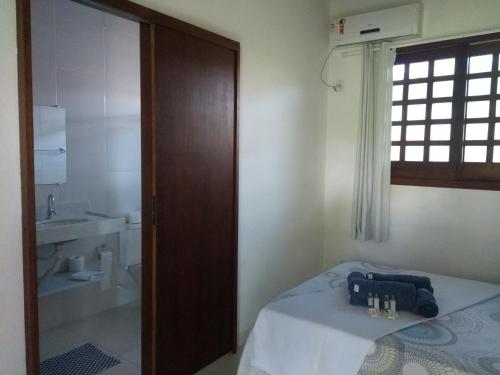 um quarto com uma cama e uma casa de banho com um lavatório em Recanto Solar da Paz na Ilha de Boipeba