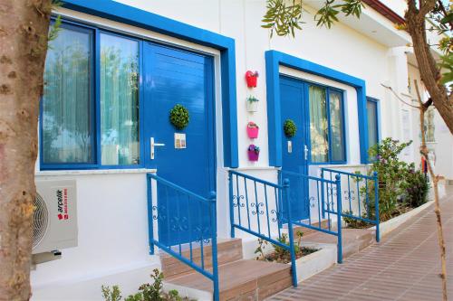 a blue door on a house with stairs at Mavi Pansiyon & Restaurant in Didim