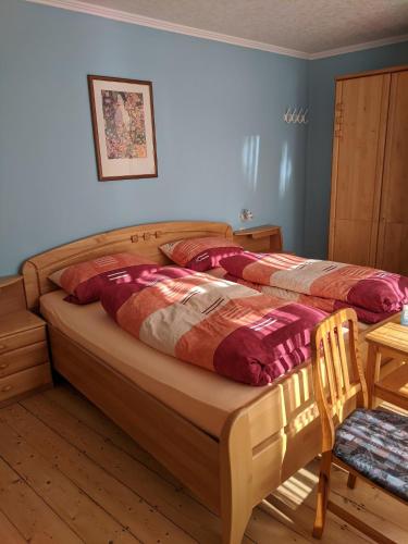 a bedroom with a large bed with a wooden frame at Weingut Pension Hammes-Krüger in Ellenz-Poltersdorf