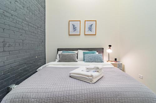 um quarto com uma cama grande e uma parede de tijolos em McCormick Place modern and cosy 420 friendly gem on Michigan avenue with optional parking for 6 guests em Chicago