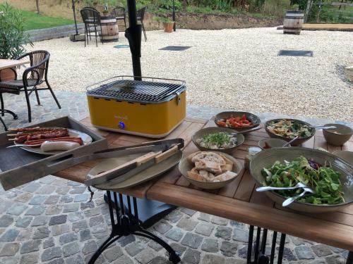 a table with a grill and plates of food on it at B & B De Romeinse Katzei in Borgloon