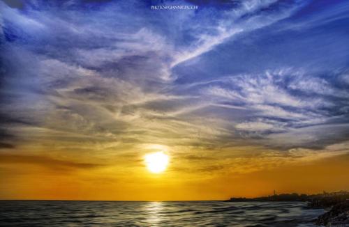 a sunset over the ocean with a cloudy sky at Terrazza Montalbano in Punta Secca