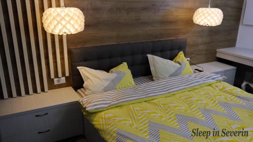 a bedroom with a bed with yellow and white sheets at Apartament ULTRACENTRAL 2 in Drobeta-Turnu Severin