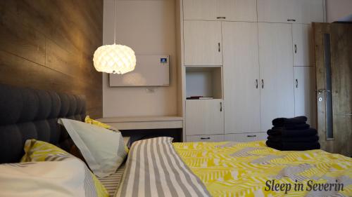 a bedroom with a bed with a yellow and white blanket at Apartament ULTRACENTRAL 2 in Drobeta-Turnu Severin