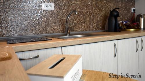 a kitchen with a sink and a wooden counter top at Apartament ULTRACENTRAL 2 in Drobeta-Turnu Severin