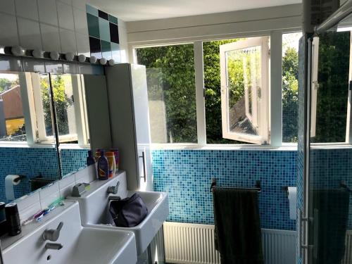 een badkamer met 2 wastafels en een spiegel bij First floor with bedroom bathroom kitchen office in Villa near TUe and Centre in Eindhoven