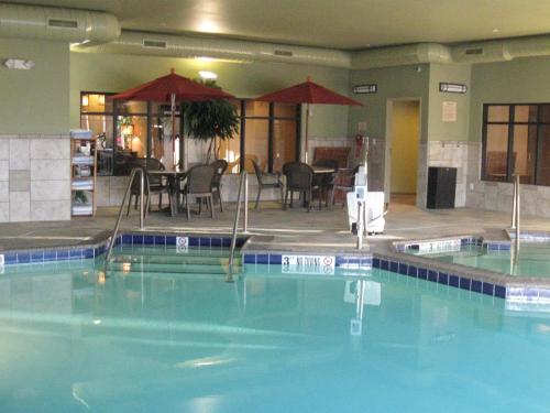 - une piscine dans un hôtel avec une table et des chaises dans l'établissement Little Missouri Inn & Suites Watford City, à Watford City