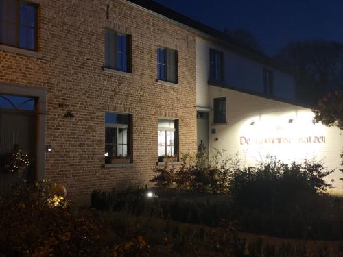 a building with a sign on the side of it at night at B & B De Romeinse Katzei in Borgloon