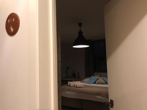 a bedroom with a bed and a clock and a light at B & B De Romeinse Katzei in Borgloon