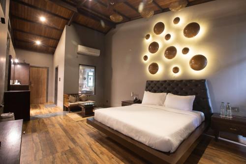 a bedroom with a large bed and a living room at Encore A Boutique Resort in Mulshi