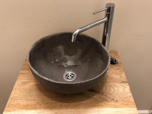 a black sink sitting on top of a wooden counter at B & B De Romeinse Katzei in Borgloon