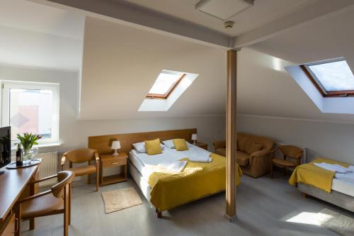 a bedroom with two beds and a table and chairs at Hotel Sport in Koszalin