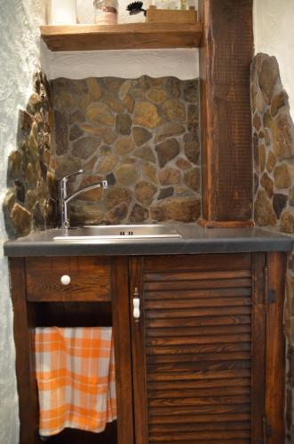 a kitchen with a sink and a stone wall at Birgits Landhaus Willingen in Willingen