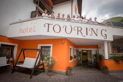 a group of people sitting on top of a hotel tooting at Hotel Touring in Predazzo