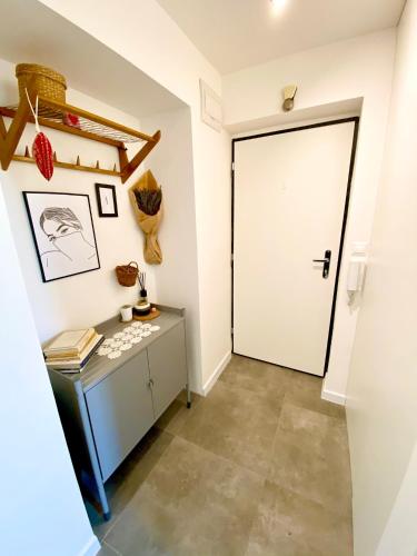a hallway with a white door and a table at Chyža retro apartmán in Prievidza