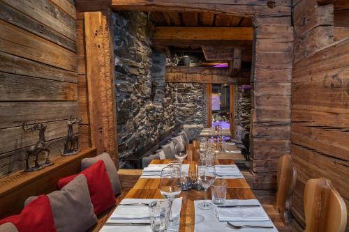 a long table in a restaurant with wooden walls at Unique Hotel Post in Zermatt