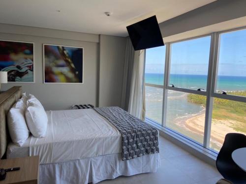 um quarto com uma cama e vista para o oceano em Paiva Flat Home Stay - Barra de Jangada em Recife