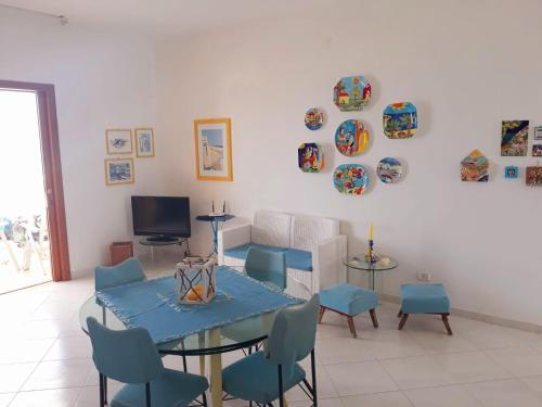 uma sala de estar com uma mesa e cadeiras e uma televisão em Castellammare Holiday em Alcamo Marina