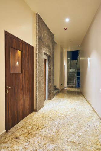 an empty hallway with a wooden door and stairs at Hotel Kiyara in Kolhapur
