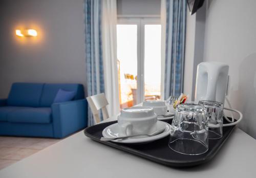 a table with a tray with plates and glasses on it at Bike&Boat Argentario Hotel in Porto Santo Stefano