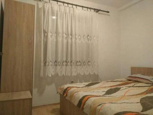 a bedroom with a bed and a white curtain at Apartments Filemi in Ohrid