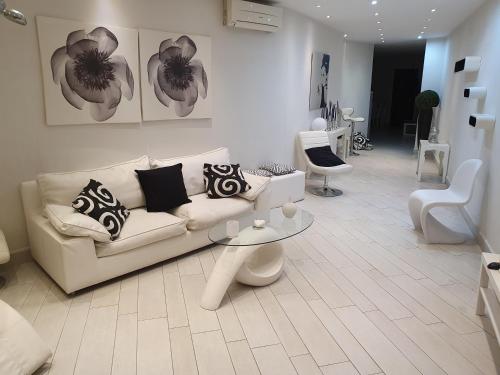 a white living room with a couch and a table at Casa Vacanza Pozzuoli in Pozzuoli